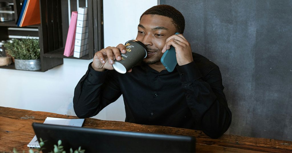 Young man taking coffee working from home